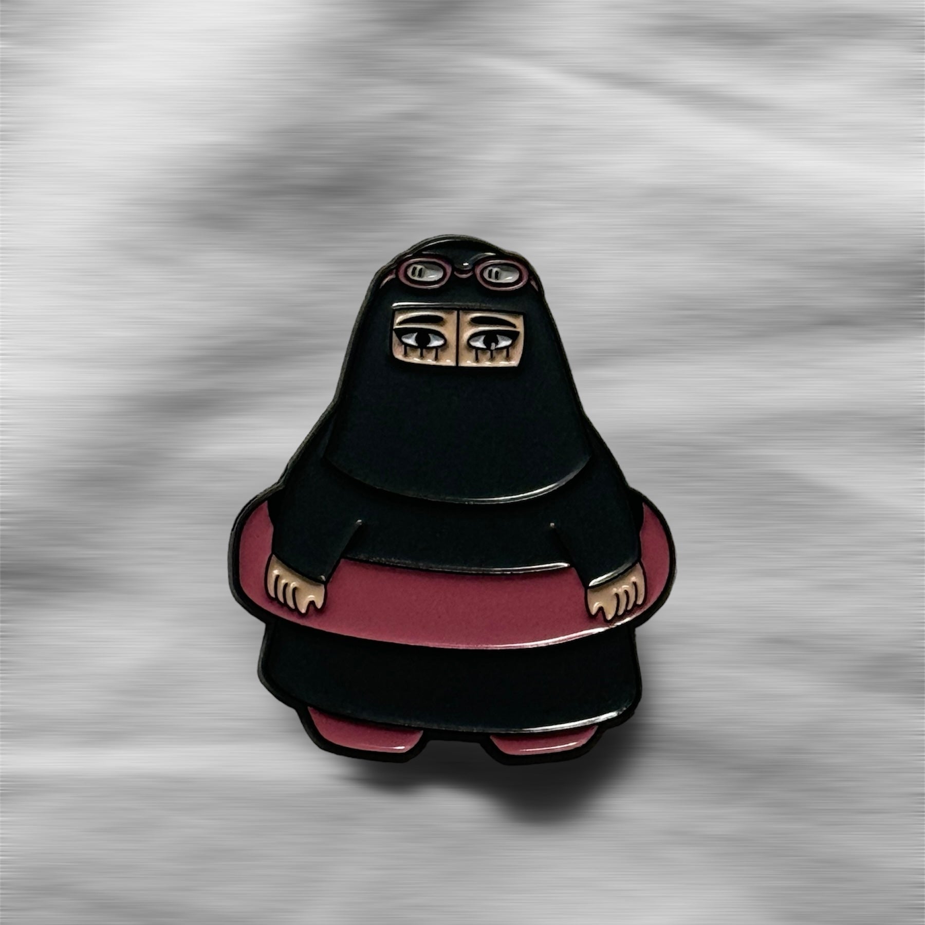 Summer Niqabi Enamel Pin featuring a niqabi woman in a cheerful summery setting. A vibrant accessory perfect for adding cultural flair and a touch of summer fun to jackets, bags, or hats, celebrating the blend of tradition and seasonal joy.